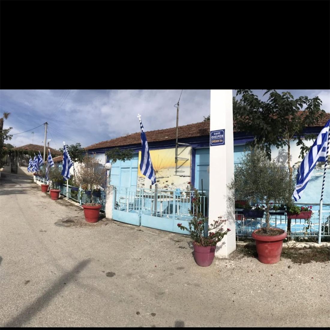 Δρόμος του Δαφνουδίου με ελληνικές σημαίες και τοιχογραφίες
